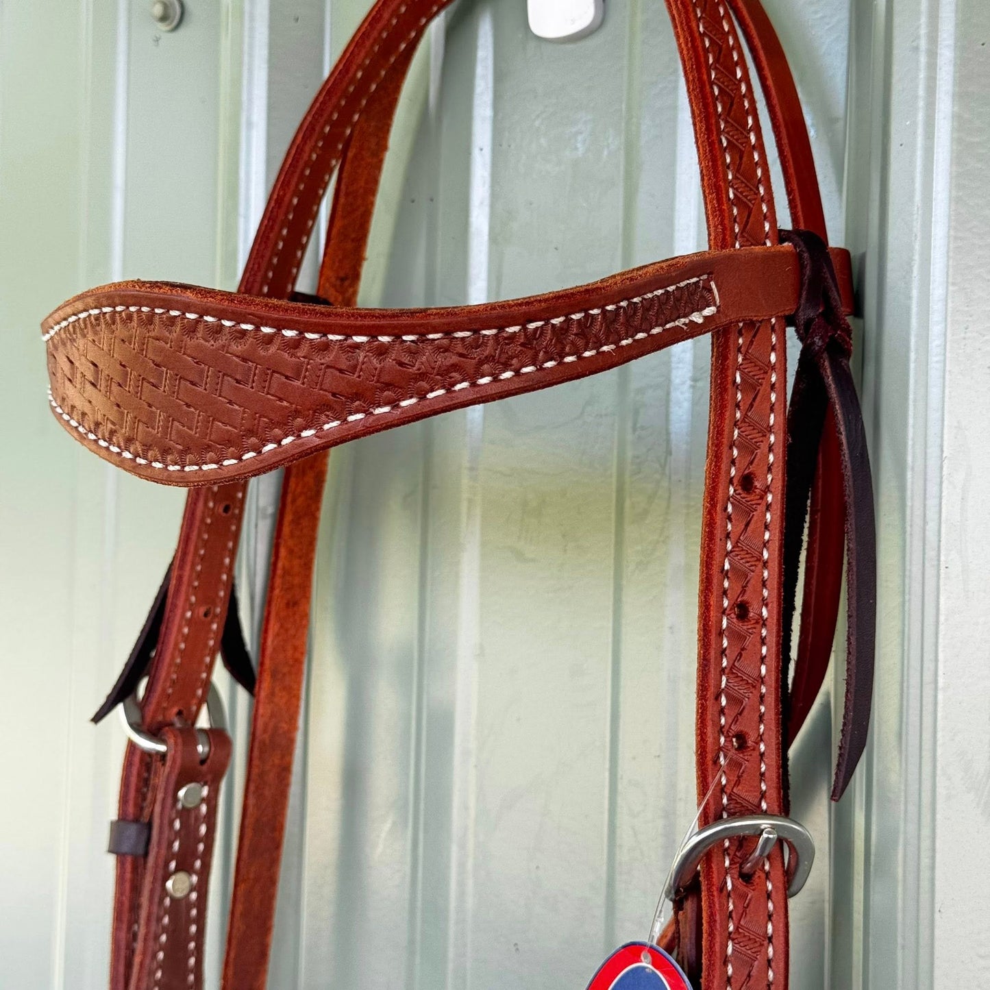 Quarter Horse wearing hand tooled basket weave cowboy headstall for ranch riding
