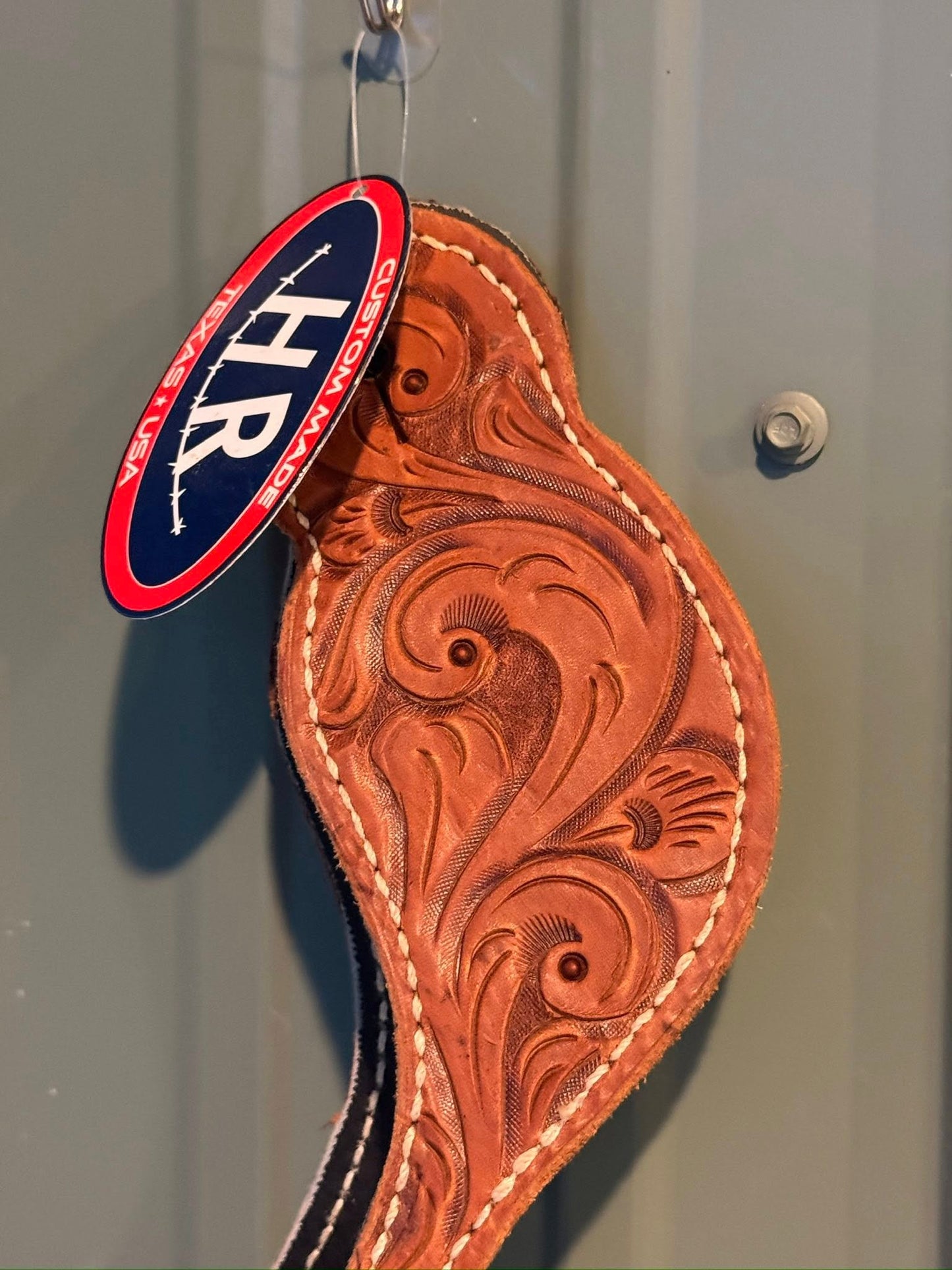 Close-up of detailed hand-tooled Western pattern on Big Sky spur straps
