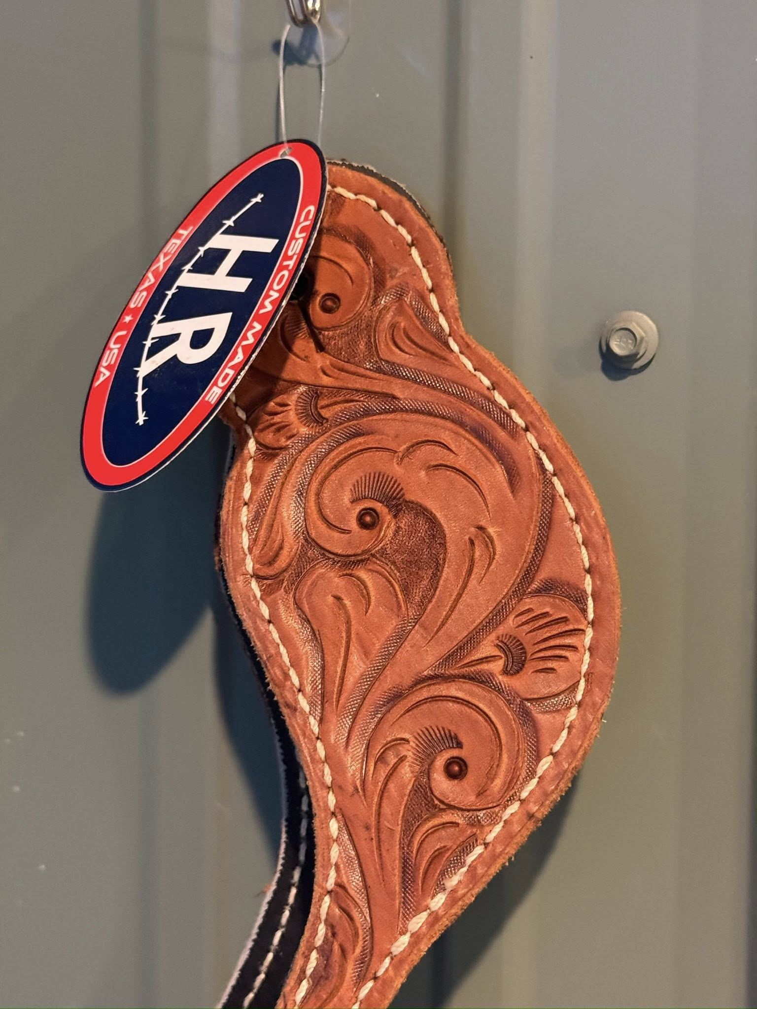 Close-up of detailed hand-tooled Western pattern on Big Sky spur straps
