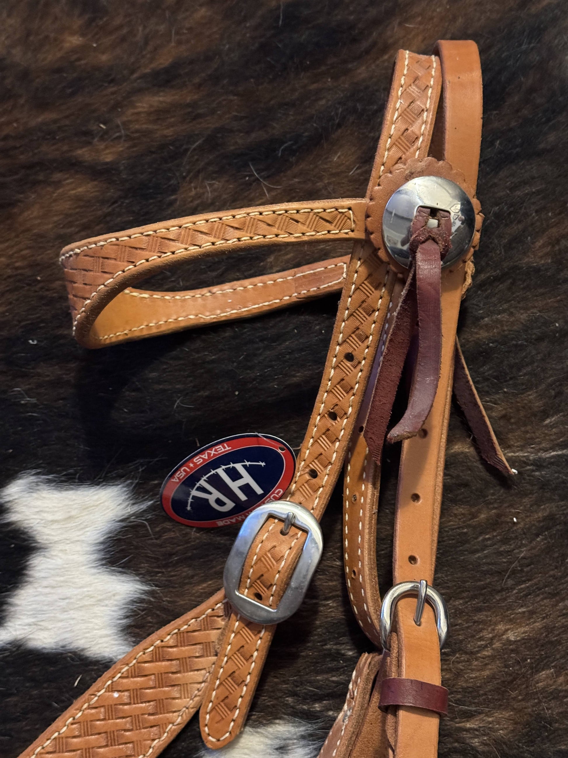 “Close-up of basket weave tooling and stainless hardware”